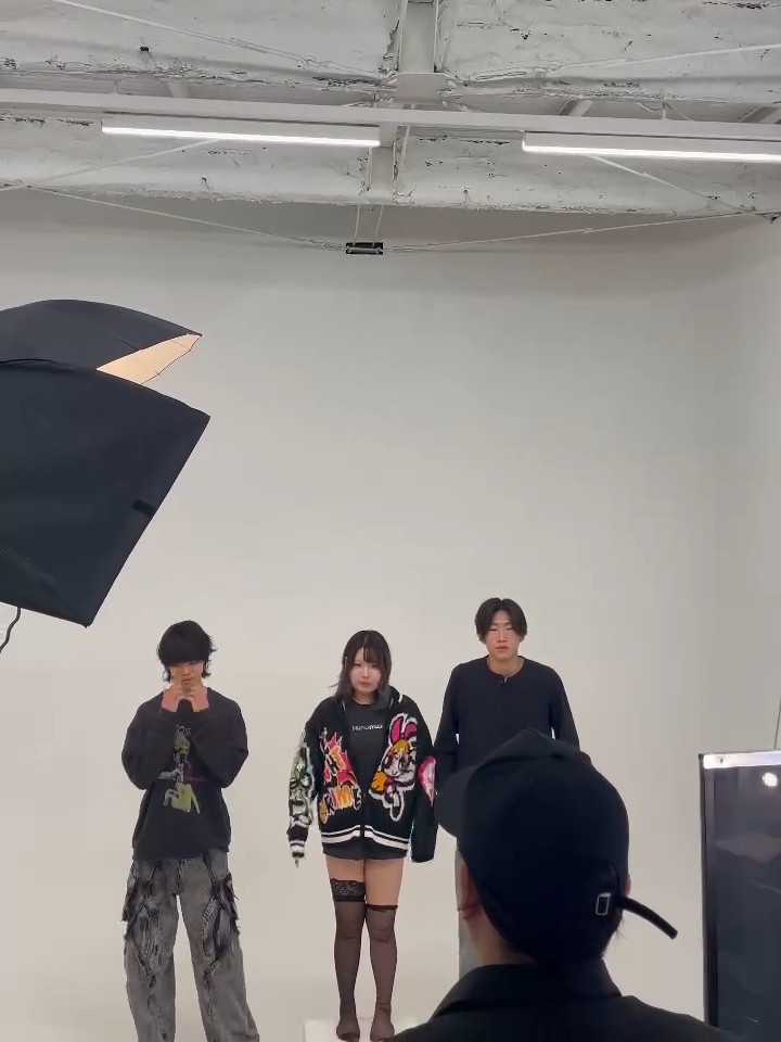 撮影風景（ライトの下に立つ3人）